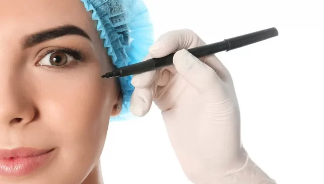 Metade do rosto de uma mulher e mão de cirurgião plástico segurando um marcador